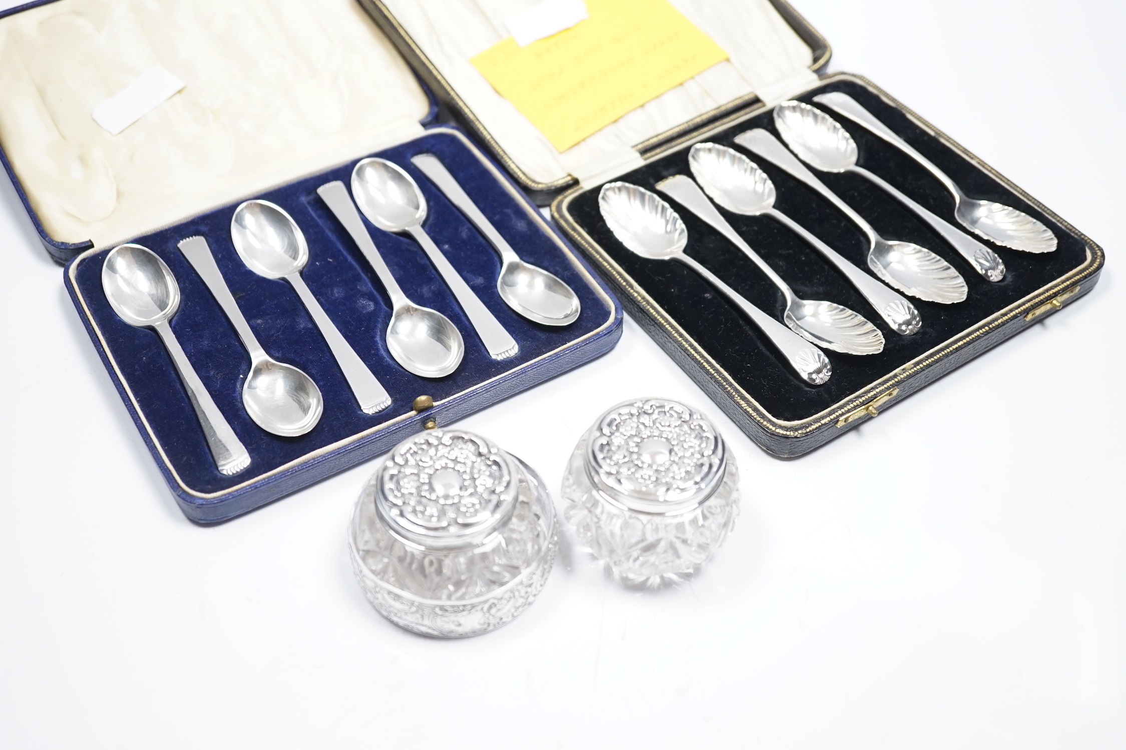 Two cased sets of six silver teaspoons, including Old English shell pattern by James Dixon & Sons, Sheffield, 1893 and Robert Pringle & Sons, Sheffield 1941, together with two silver mounted glass toilet jars and a sterl